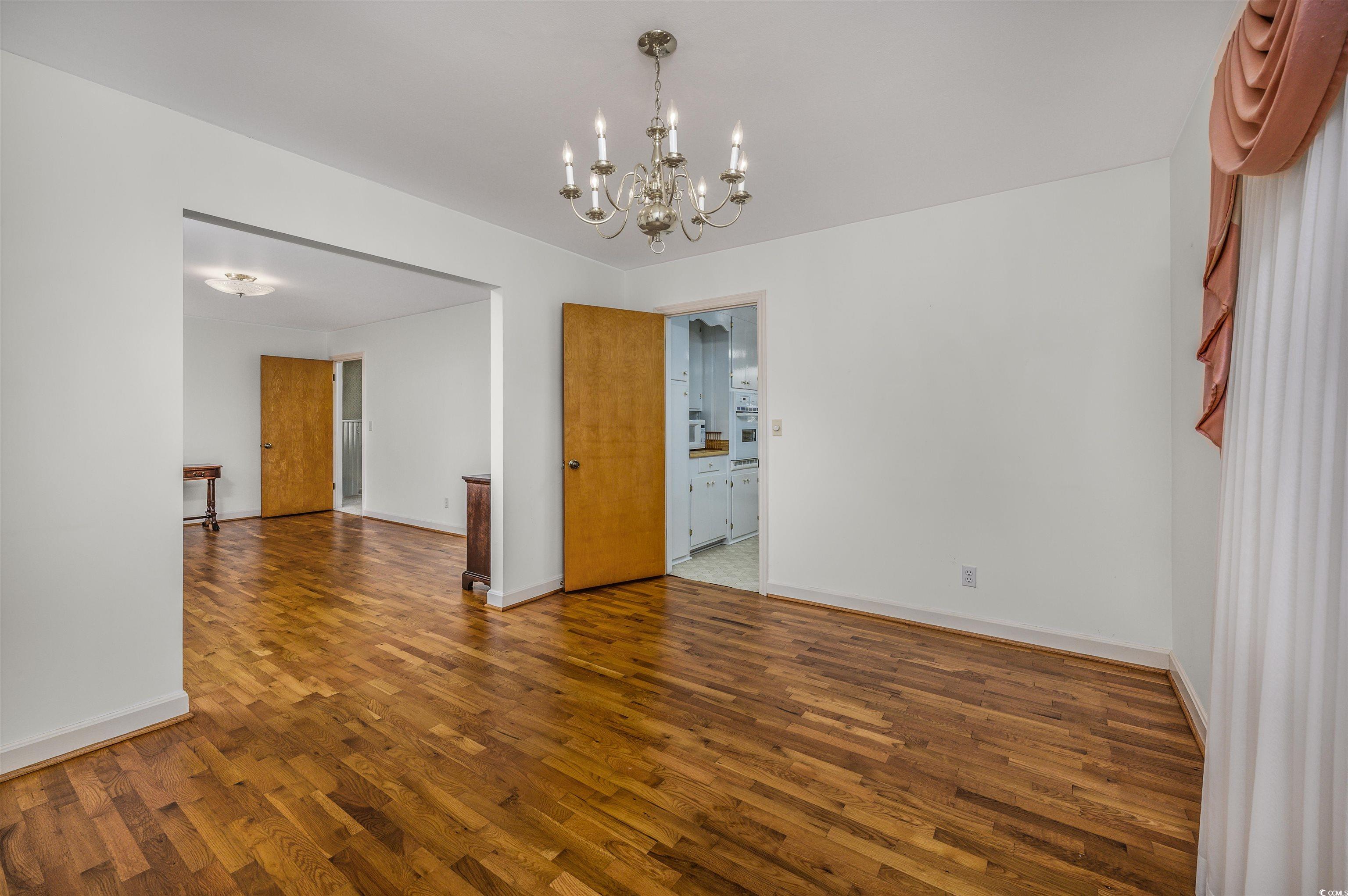 1870 Highway 348 Loris, SC 29569 - Photo 6 of 34 Unfurnished dining area featuring wood finished floors and a chandelier