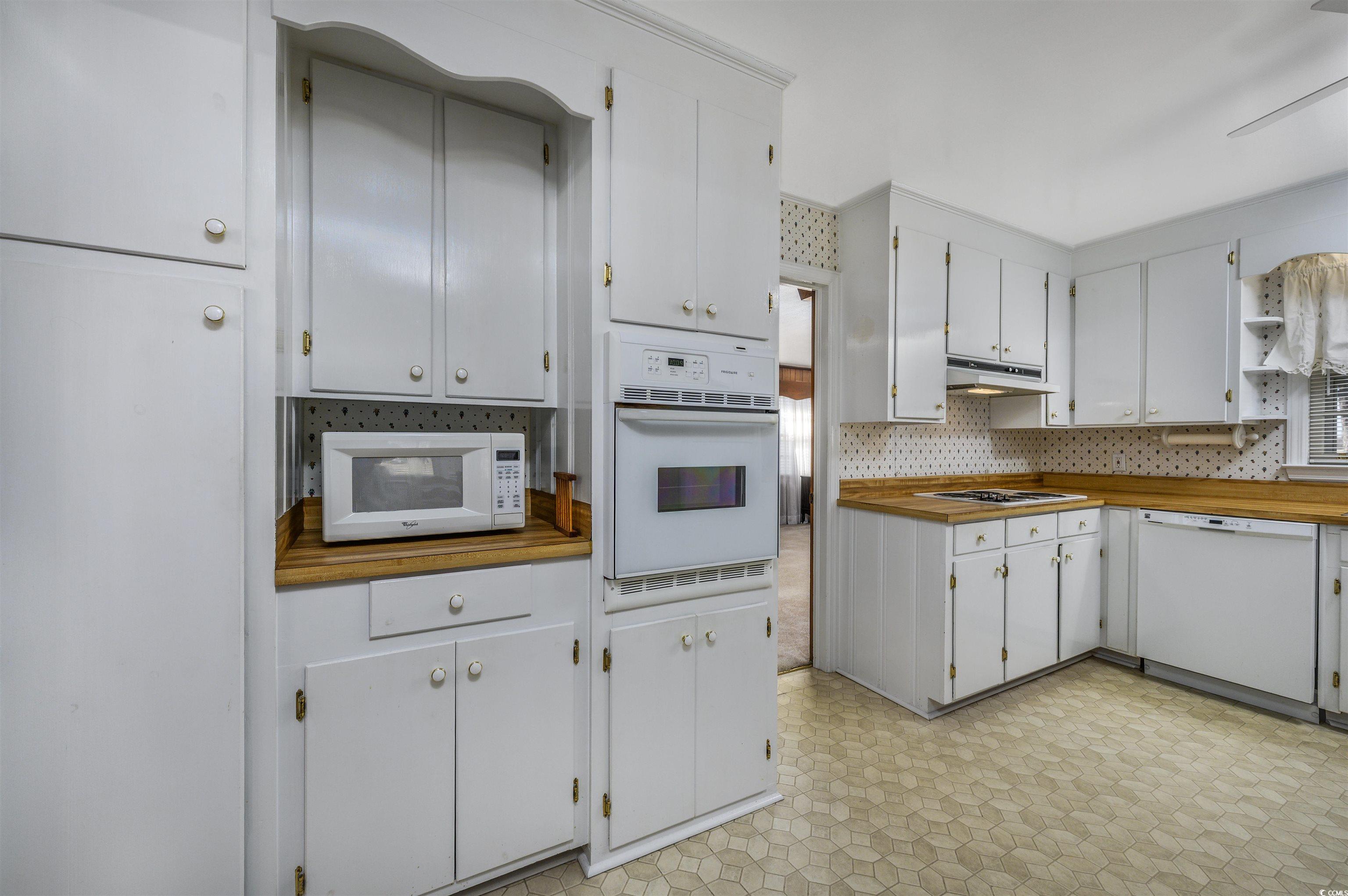 1870 Highway 348 Loris, SC 29569 - Photo 7 of 34 Kitchen featuring light flooring, open shelves, white appliances, white cabinets, and wooden counters