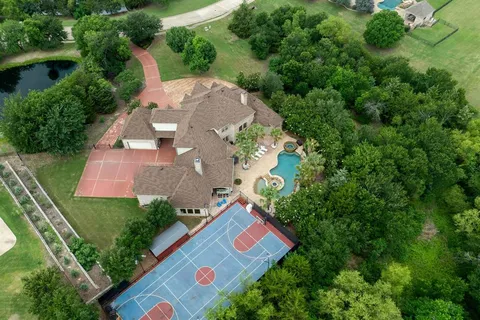 an aerial view of a house with swimming pool a yard and outdoor seating