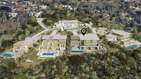 an aerial view of a residential apartment building with a yard and parking spaces