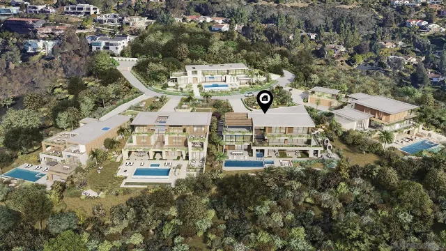 an aerial view of a residential apartment building with a yard and parking spaces