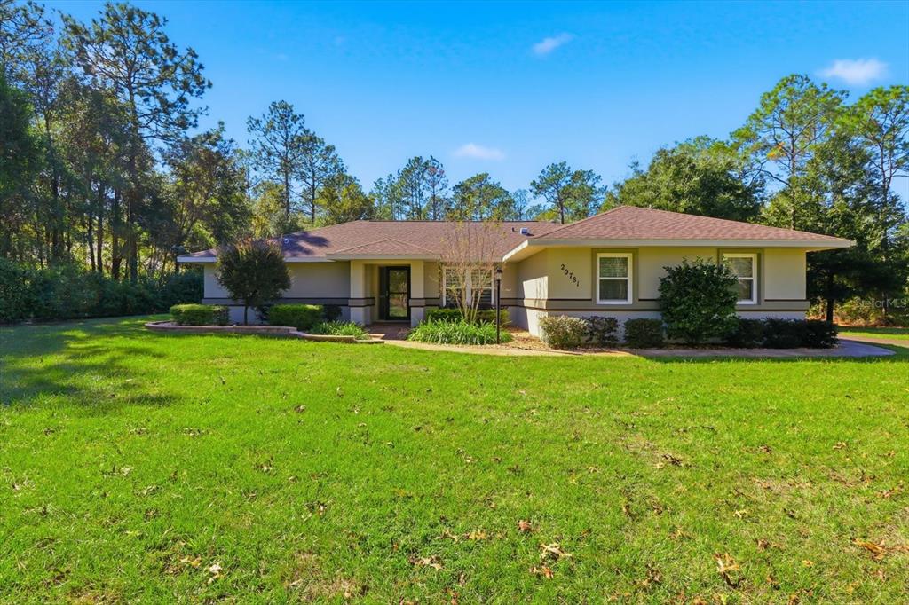 20781 Southwest 90th Loop Dunnellon, FL 34431 - Photo 1 of 46 a front view of a house with a yard table and chairs