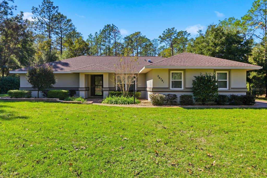 20781 Southwest 90th Loop Dunnellon, FL 34431 - Photo 32 of 46 a front view of a house with a garden