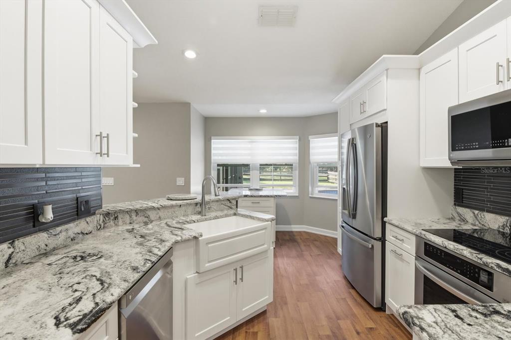 20781 Southwest 90th Loop Dunnellon, FL 34431 - Photo 10 of 46 a kitchen with granite countertop a sink stove and refrigerator