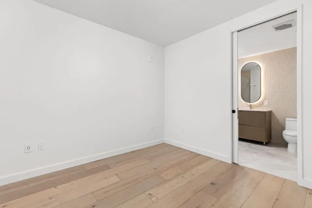 a view of a room with wooden floor and white walls