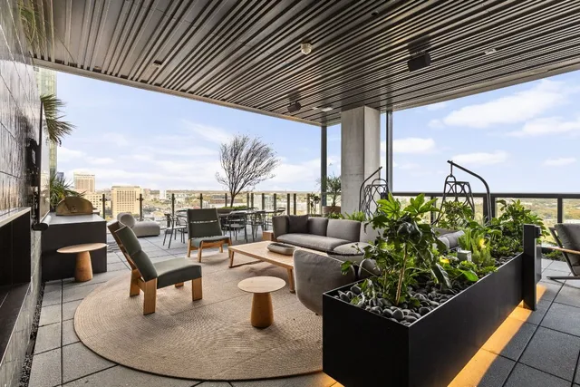 a living room with patio furniture and a potted plant