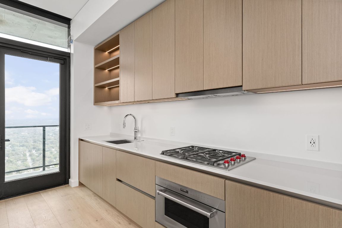 610 Davis Street, Unit 4008 Austin, TX 78701 - Photo 8 of 40 a kitchen with stainless steel appliances granite countertop a sink and a stove