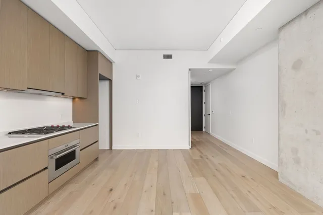 a view of a kitchen with wooden floor and a stove top oven