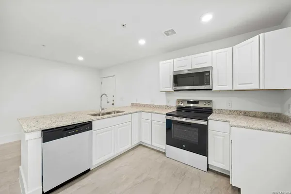 a kitchen with stainless steel appliances granite countertop a stove and a sink