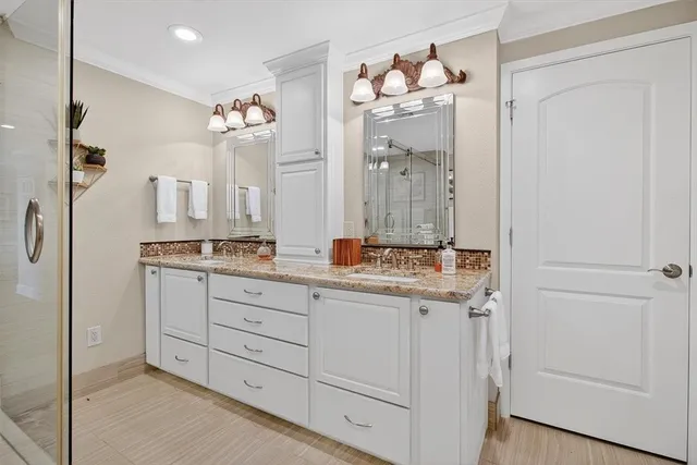 a bathroom with a granite countertop sink a mirror and a shower
