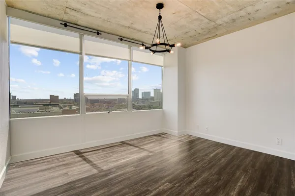 a view of a big room with wooden floor and windows