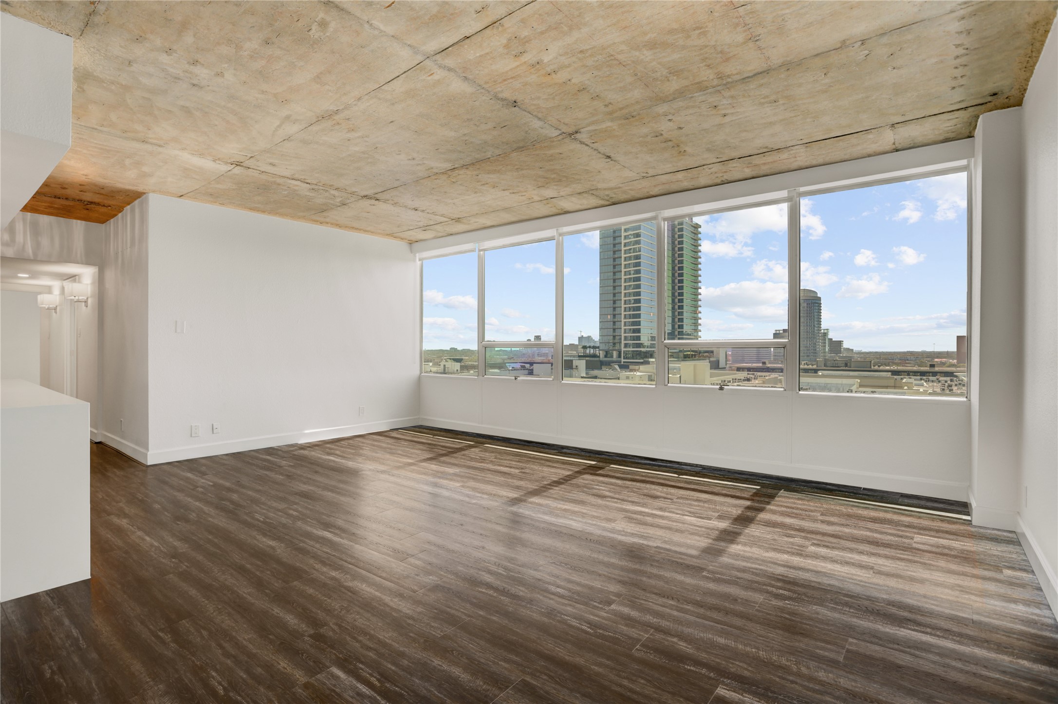 2701 Westheimer Road, Unit 12E Houston, TX 77098 - Photo 8 of 31 a view of an empty room with wooden floor and a window