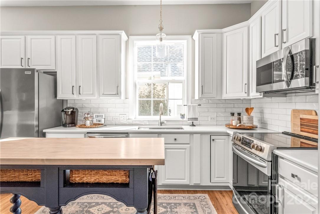 4108 Cedar Point Avenue Matthews, NC 28104 - Photo 11 of 41 a kitchen with stainless steel appliances granite countertop a stove a sink dishwasher and a refrigerator