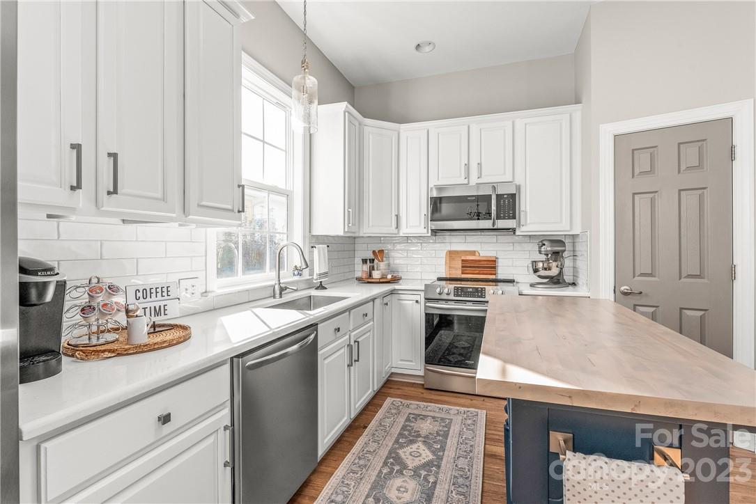 4108 Cedar Point Avenue Matthews, NC 28104 - Photo 12 of 41 a kitchen with kitchen island white cabinets and appliances