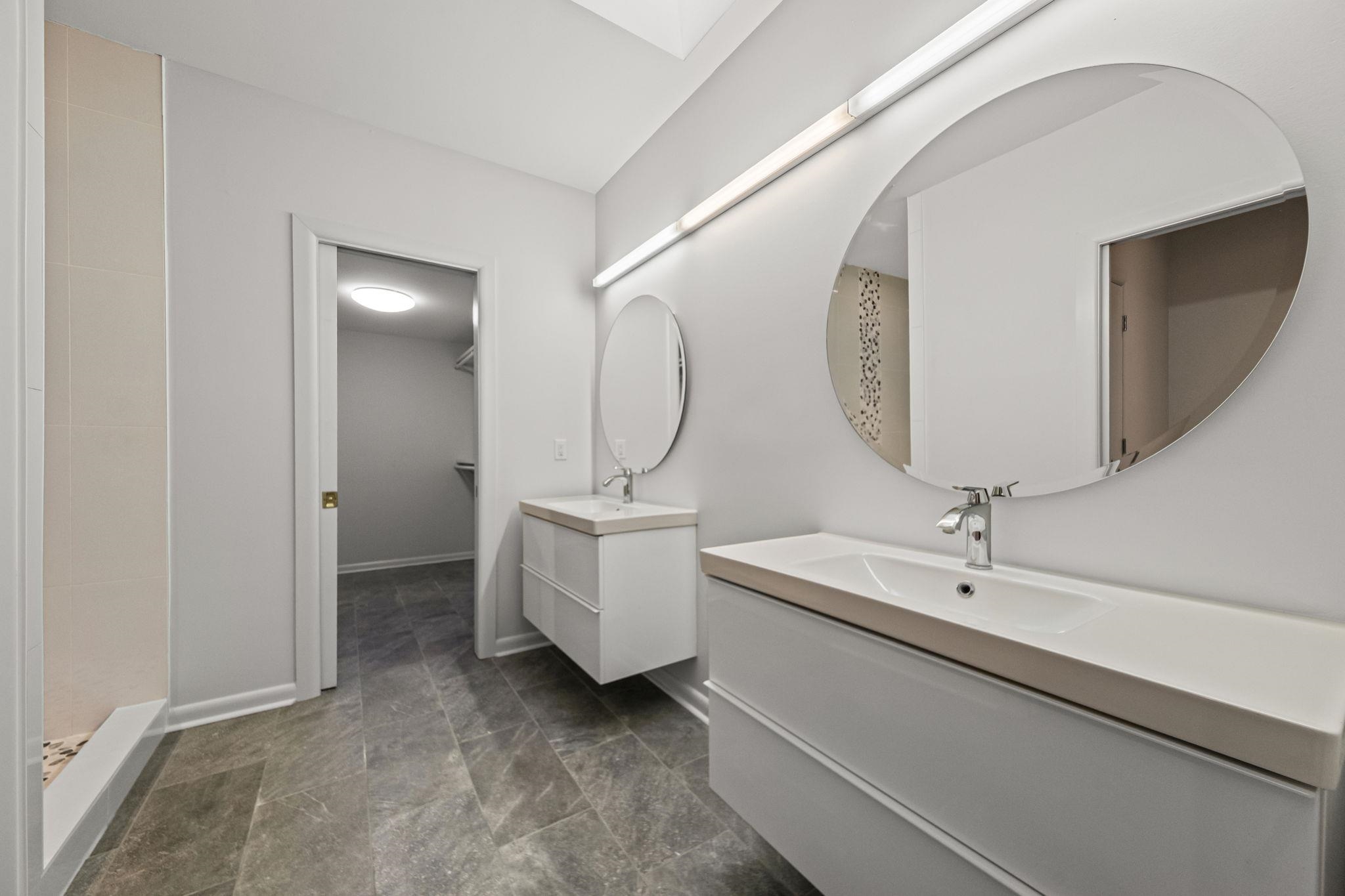 448 Tennessee Street Memphis, TN 38103 - Photo 23 of 39 Bathroom featuring dual floating vanities with integrated sinks, contemporary chrome faucets, and circular mirrors