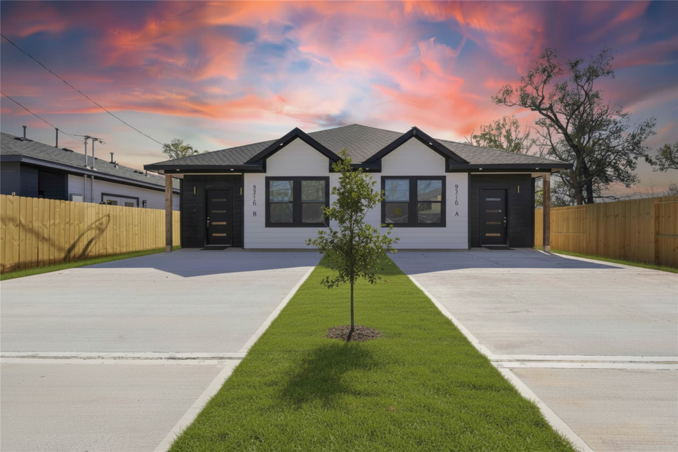 a view of a house with a yard and a large tree