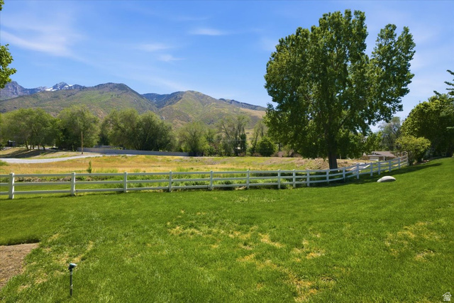 12317 Cypress Point Way Draper, UT 84020 - Photo 39 of 41 Expansive green lawn bordered by a white fence, with a large mature tree and distant mountains