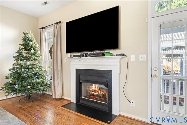 a living room with a fireplace a flat screen tv and a christmas tree