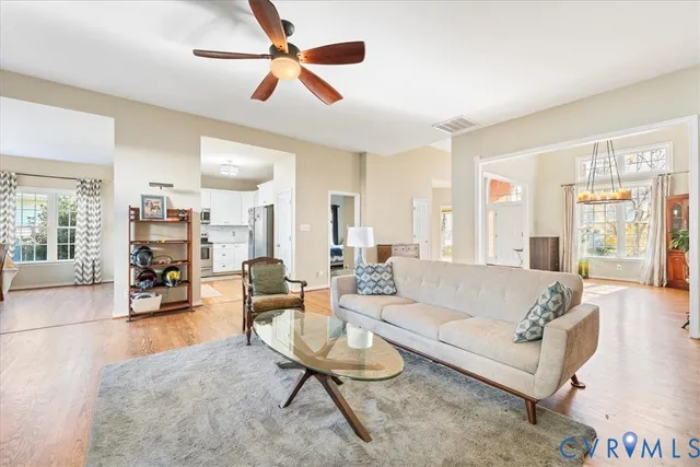 a living room with furniture and a large window with wooden floor