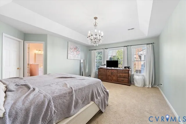 a bedroom with a large bed and a chandelier