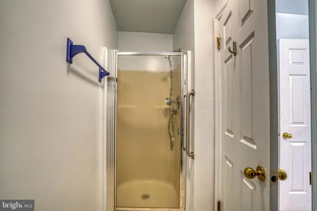 a bathroom with a glass shower door and a mirror