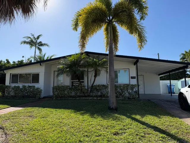 a front view of house with yard and potted plants