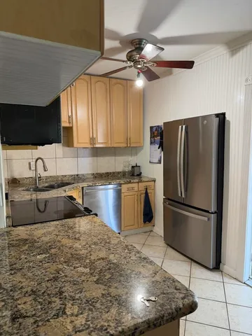 a kitchen with stainless steel appliances granite countertop a refrigerator a sink a stove a microwave and island