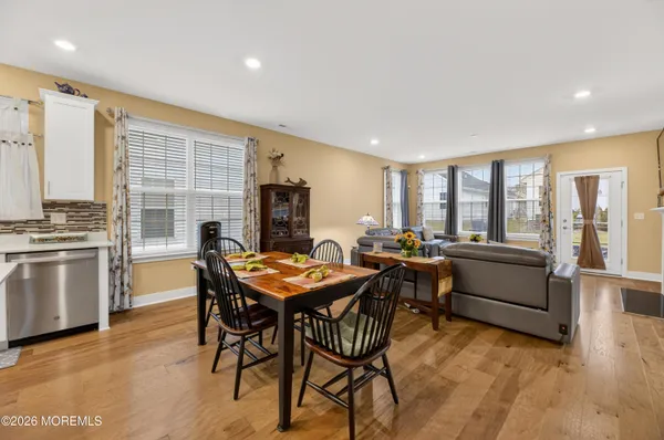 a living room with furniture kitchen view and a chandelier