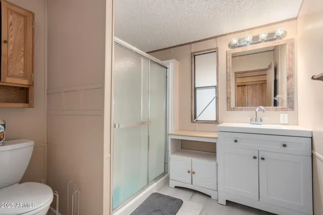 a bathroom with a sink a toilet a mirror and a window