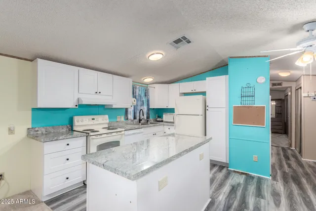 a kitchen with white cabinets and refrigerator