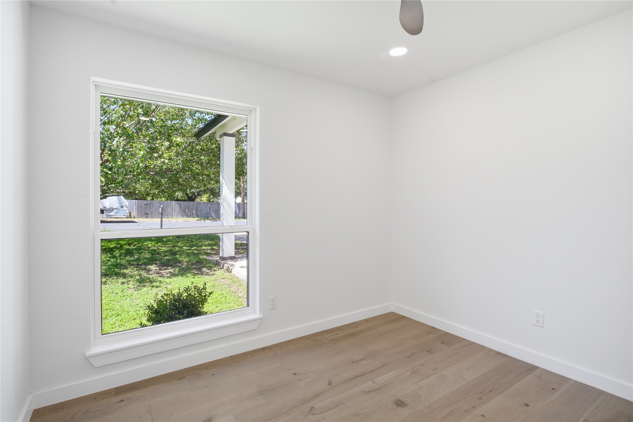 2110 Magazine Street Austin, TX 78727 - Photo 16 of 31 Spacious bedroom featuring a large window, recessed lighting, wood-finish flooring, and white baseboards