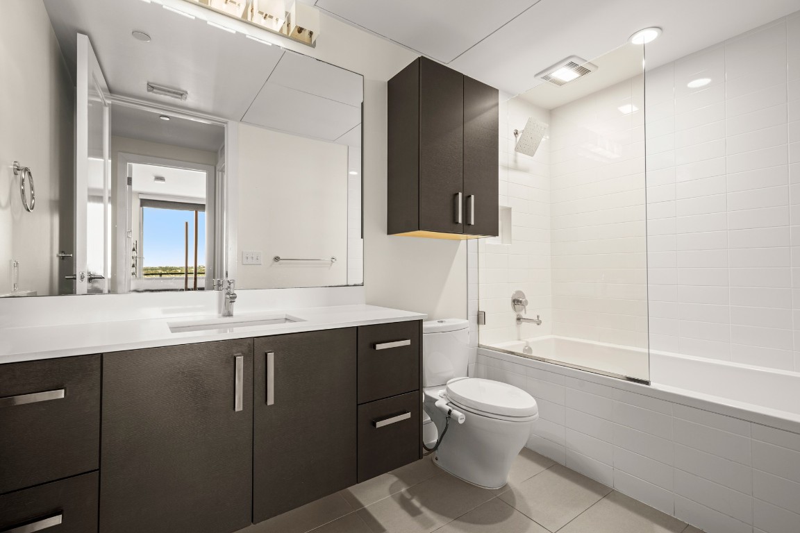 222 West Avenue, Unit 2012 Austin, TX 78701 - Photo 14 of 37 a bathroom with a sink a toilet and a large mirror