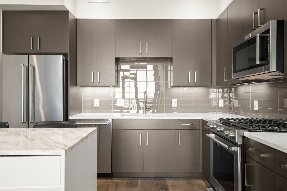 222 West Avenue, Unit 2012 Austin, TX 78701 - Photo 4 of 37 a kitchen with kitchen island granite countertop a sink stove and refrigerator