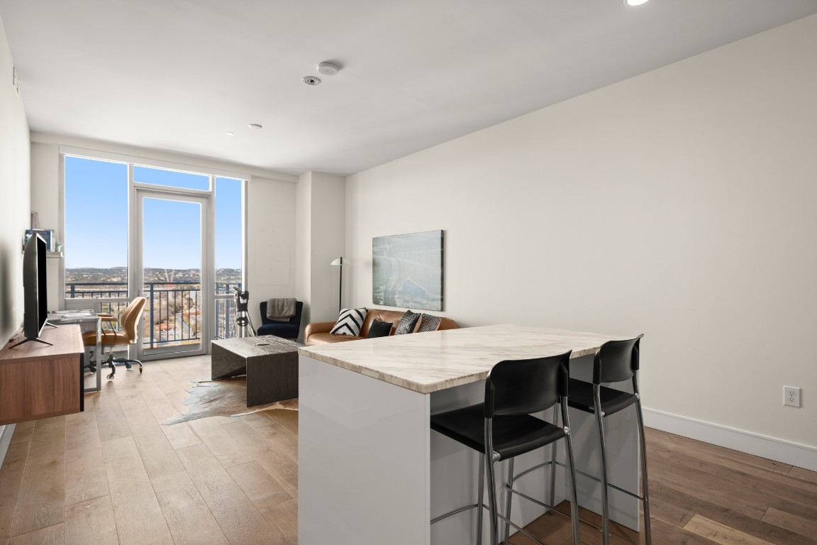 222 West Avenue, Unit 2012 Austin, TX 78701 - Photo 6 of 37 a living room with furniture a flat screen tv and a floor to ceiling window