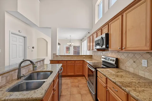 a kitchen with stainless steel appliances granite countertop a sink stove and cabinets