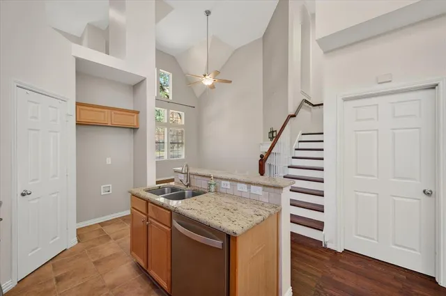 a kitchen with stainless steel appliances granite countertop a sink and a refrigerator