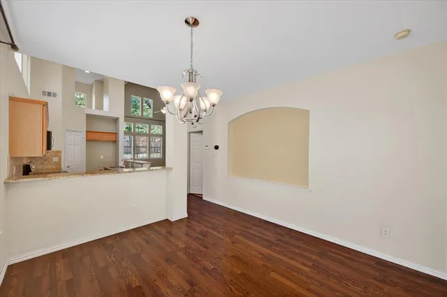 a view of a room with wooden floor and chandelier