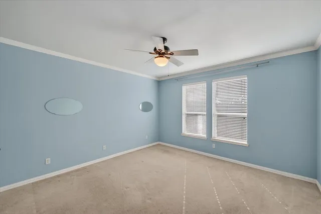 an empty room with windows and fan