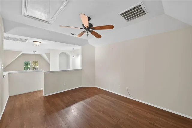 a view of a room with wooden floor and ceiling fan
