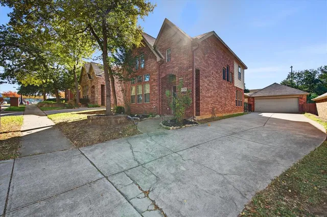 a view of a house with a yard and large tree