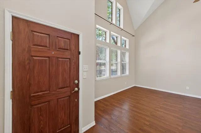 a view of empty room with wooden floor and entryway