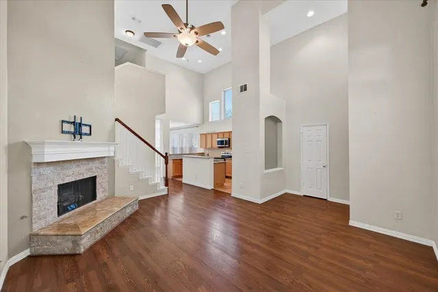 a view of an empty room with wooden floor fireplace and a window