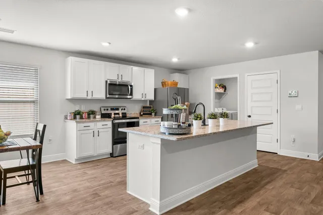 a kitchen with refrigerator a microwave a stove and cabinets