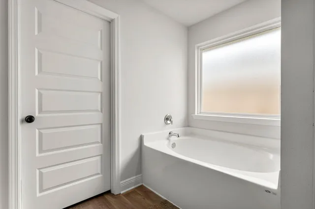 a bathroom with a bathtub and a window