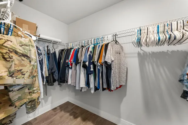 a view of walk in closet with clothes