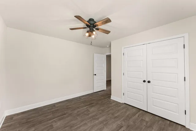 an empty room with a window and a ceiling fan