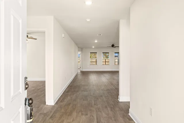 a view of a hallway with wooden floor
