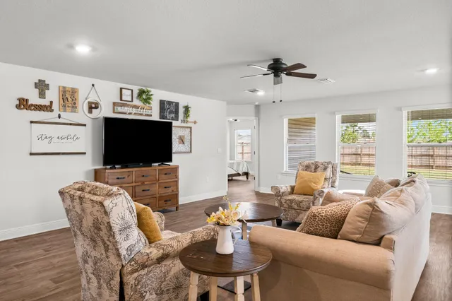 a living room with furniture a flat screen tv and a large window