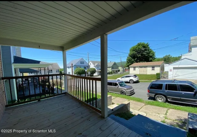 a view of a house with wooden deck and furniture