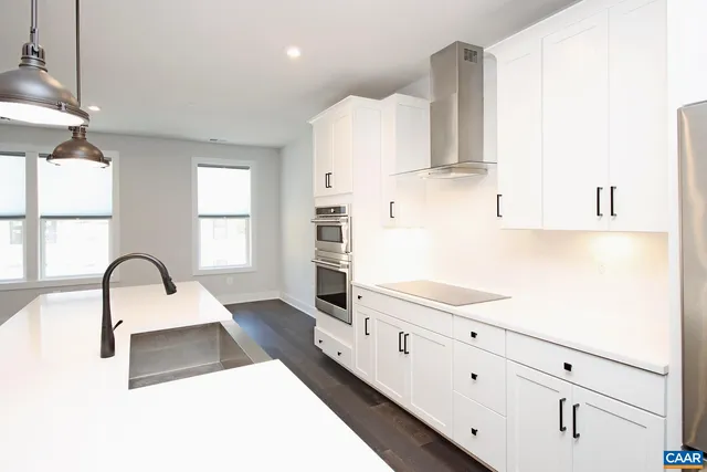 a kitchen with granite countertop white cabinets and sink